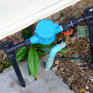Old And Dirty Tab Water Pipe And Meter With Waterspout On Ground Floor.